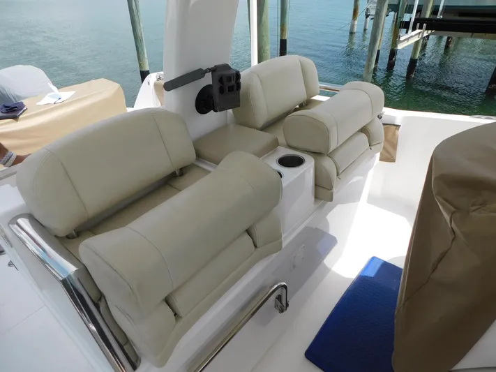 Happily Ever After Yacht Photos Pics Luxurious seating on a 2016 Belzona 327 WA boat, featuring beige cushions and ocean backdrop.