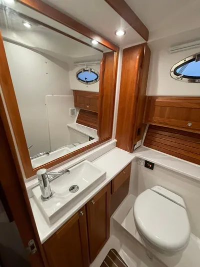 Silver Lining Yacht Photos Pics 2021 Back Cove 34 O yacht bathroom with wooden cabinetry and modern fixtures.
