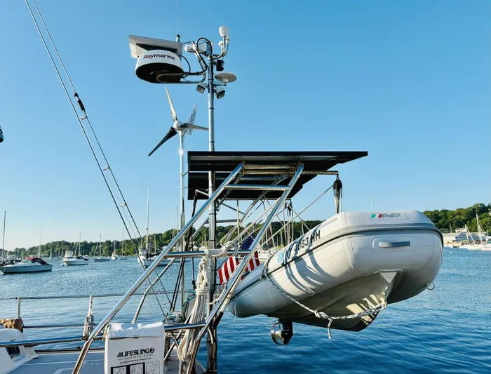 Calliope Yacht Photos Pics Sailboat Island Packet 485 (2007) with dinghy and solar panels in a marina.