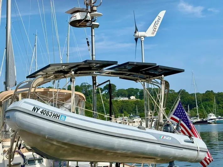 Calliope Yacht Photos Pics 2007 Island Packet 485 sailboat with dinghy, solar panels, and wind turbine at marina.