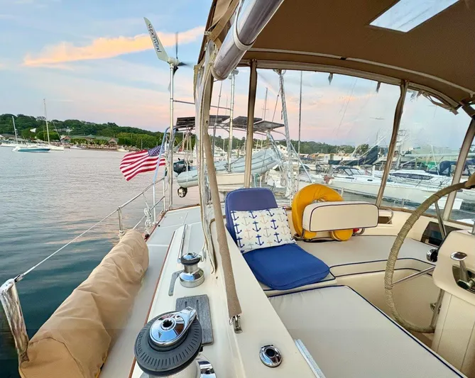 Calliope Yacht Photos Pics 2007 Island Packet 485 sailboat cockpit with seating, American flag, and marina view.