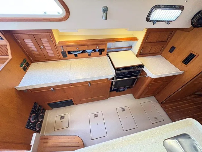 Calliope Yacht Photos Pics 2007 Island Packet 485 yacht kitchen with wooden cabinets and modern appliances.