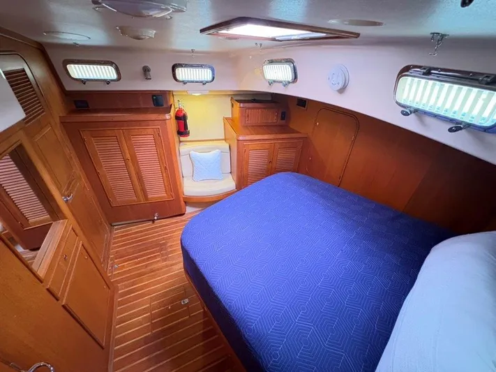 Calliope Yacht Photos Pics Luxurious cabin interior of 2007 Island Packet 485 yacht with wooden furnishings and blue bedding.