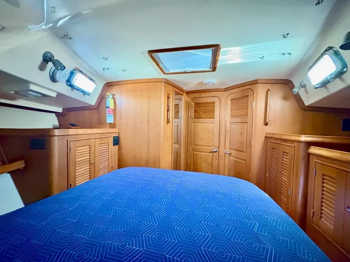 Calliope Yacht Photos Pics Interior cabin of 2007 Island Packet 485 yacht with wooden finishes and blue bedding.