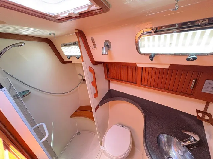 Calliope Yacht Photos Pics Luxurious 2007 Island Packet 485 yacht bathroom with shower, sink, and wooden accents.