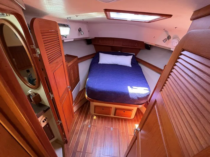 Calliope Yacht Photos Pics Cozy cabin interior of 2007 Island Packet 485 sailboat with wooden finishes and bed.