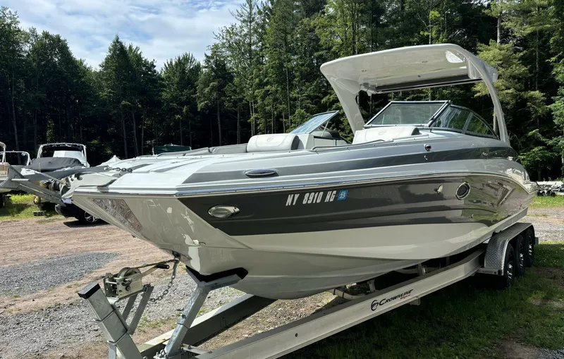  Yacht Photos Pics 2021 Crownline E305XS boat on trailer in wooded area.