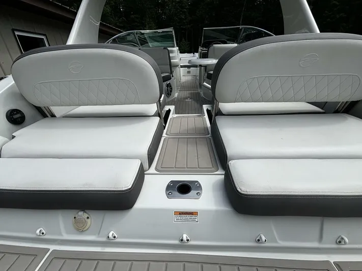  Yacht Photos Pics 2021 Crownline E305XS boat interior with white cushioned seating and sleek design.