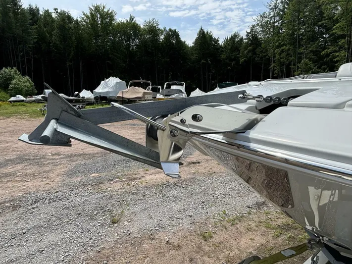  Yacht Photos Pics 2021 Crownline E305XS boat anchor detail in a wooded outdoor setting.