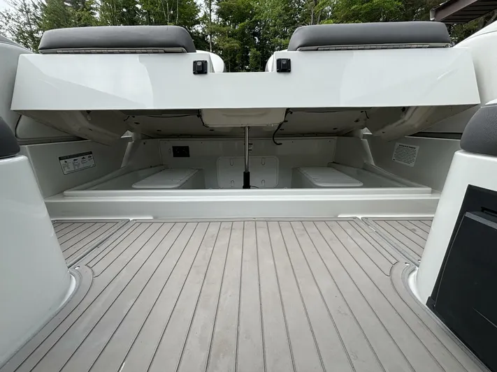  Yacht Photos Pics 2021 Crownline E305XS boat storage compartment with open hatch, showcasing spacious interior.