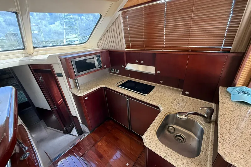  Yacht Photos Pics Luxurious 2005 Sea Ray 500 Sedan Bridge yacht kitchen with modern amenities and wood finishes.
