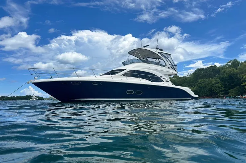 Yacht Photos Pics 2005 Sea Ray 500 Sedan Bridge yacht on calm water under blue sky.