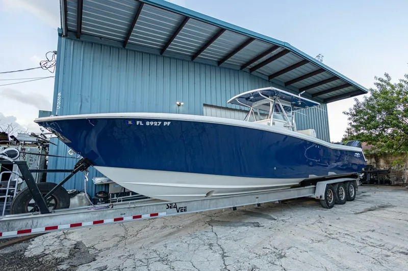 Sindylou Yacht Photos Pics 2012 Invincible 36 Open Fisherman boat on trailer, blue hull, parked by a metal building.