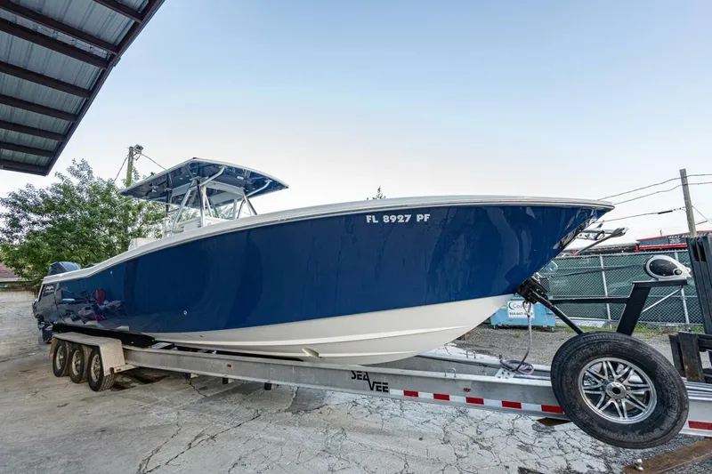 Sindylou Yacht Photos Pics 2012 Invincible 36 Open Fisherman boat on trailer, blue hull, parked outdoors.