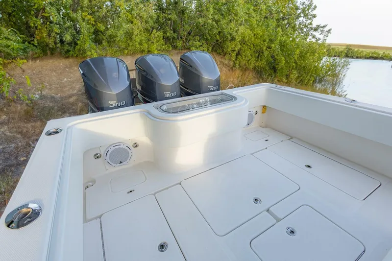 Sindylou Yacht Photos Pics 2012 Invincible 36 Open Fisherman boat with triple Yamaha 300 engines, docked near lush greenery.