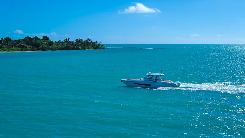  Yacht Photos Pics Boston Whaler 420 Outrage 2017 cruising on turquoise ocean near tropical island.