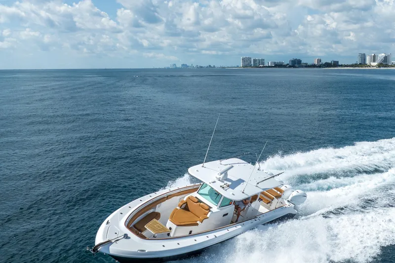 Sun Owl Yacht Photos Pics 2020 HCB 42 Lujo boat cruising on open water near a city skyline.