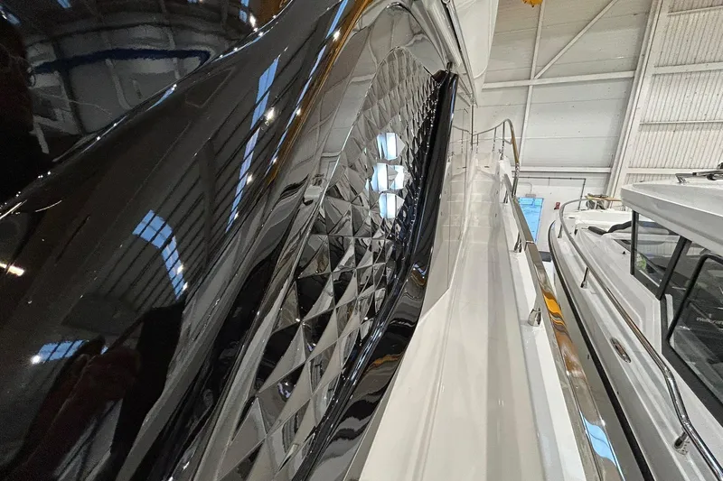  Yacht Photos Pics Sleek 2026 Prestige F4.9 yacht with glossy black and white exterior in a showroom.