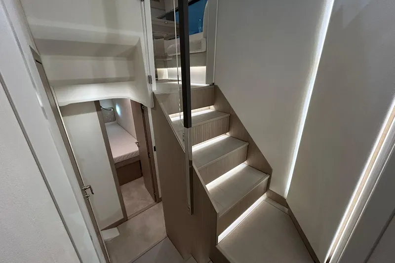  Yacht Photos Pics Modern interior of 2026 Prestige F4.9 yacht with illuminated staircase and cozy cabin.