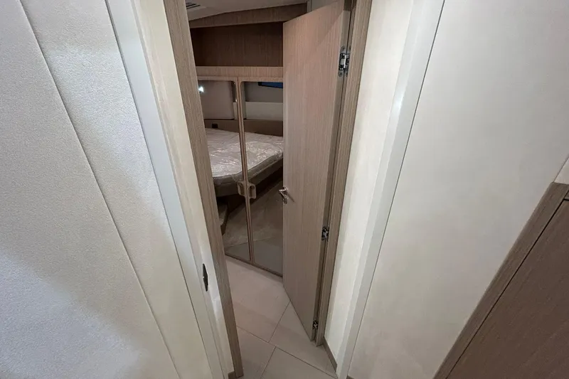  Yacht Photos Pics Modern interior of Prestige F4.9 yacht, featuring a cozy bedroom with wooden accents, 2026 model.