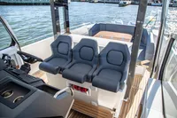 2022 Nimbus T11 boat interior with three cushioned seats and a wooden deck.