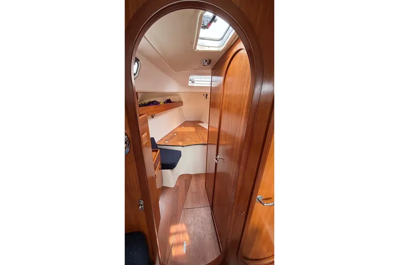 Tarahumara Yacht Photos Pics Interior of 2008 J Boats J/122 sailboat, featuring wooden cabinetry and cozy sleeping area.