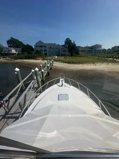 Lola Yacht Photos Pics Cabo 35 Flybridge 2005 at dock with coastal houses in background.