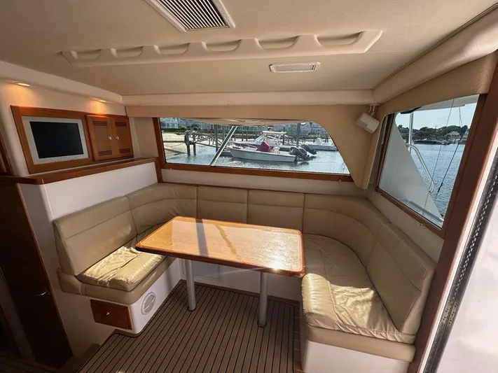 Lola Yacht Photos Pics Interior of 2005 Cabo 35 Flybridge with seating area and table.