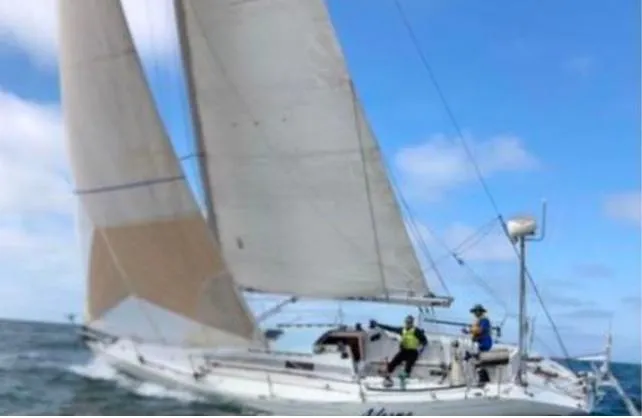 Sailing yacht Beneteau First Class 12, 1988 model, navigating ocean waters under clear skies.