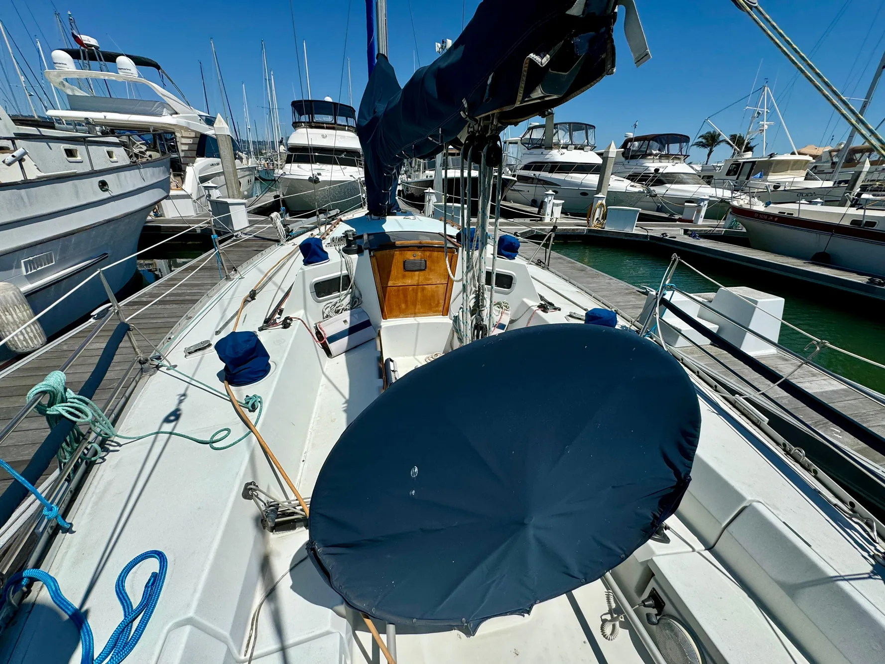 1988 Beneteau First Class 12 sailboat docked in a marina, surrounded by other boats.