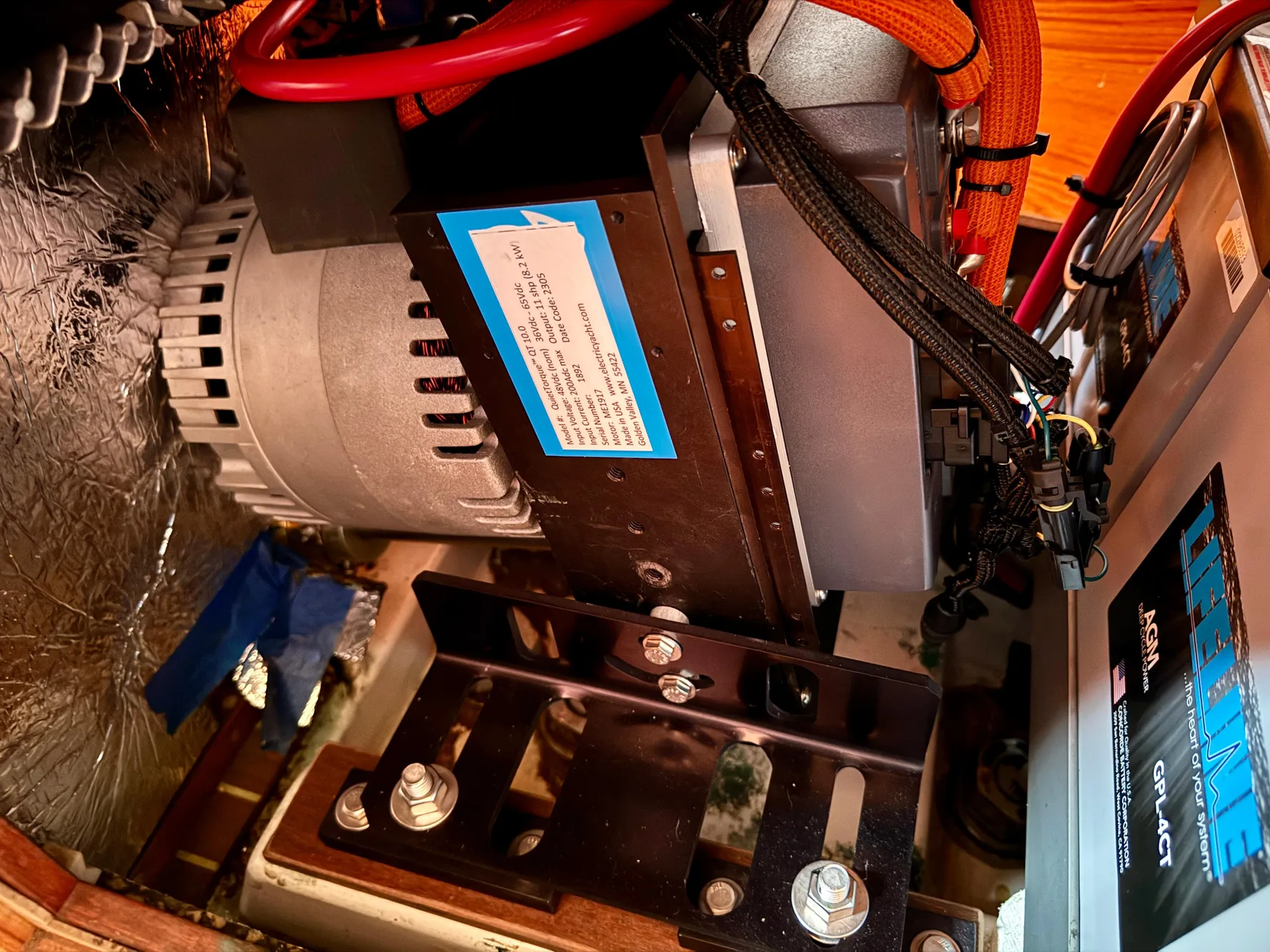 Engine compartment of a 1988 Beneteau First Class 12 sailboat, featuring mechanical components and wiring.