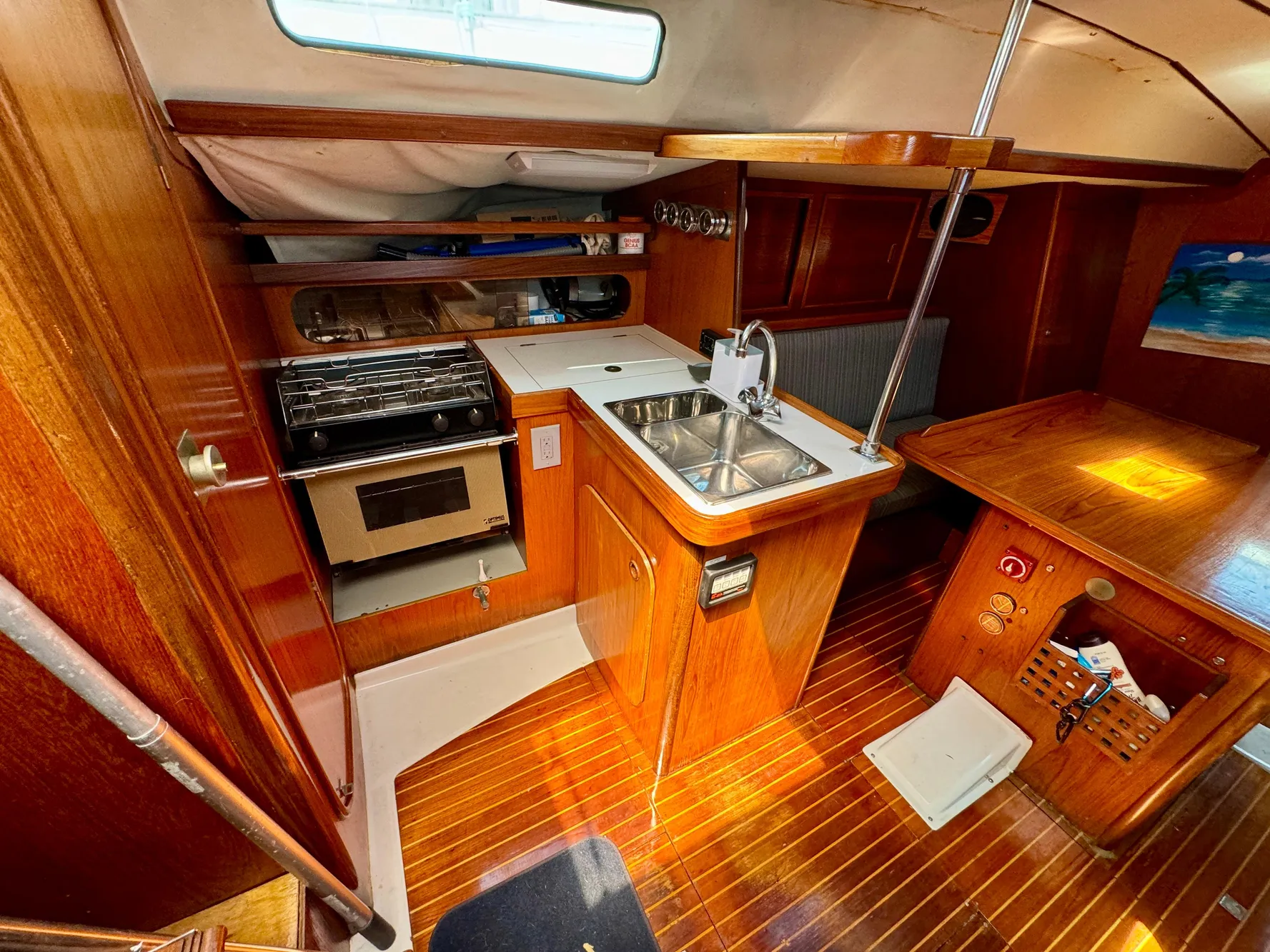1988 Beneteau First Class 12 yacht interior with kitchen and dining area.