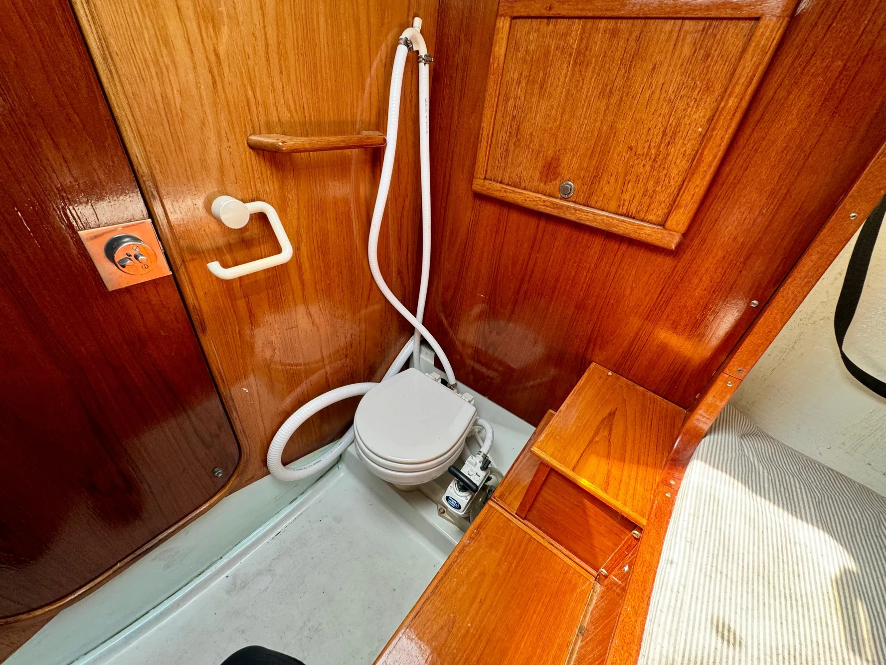 1988 Beneteau First Class 12 yacht bathroom with wooden interior and compact toilet.