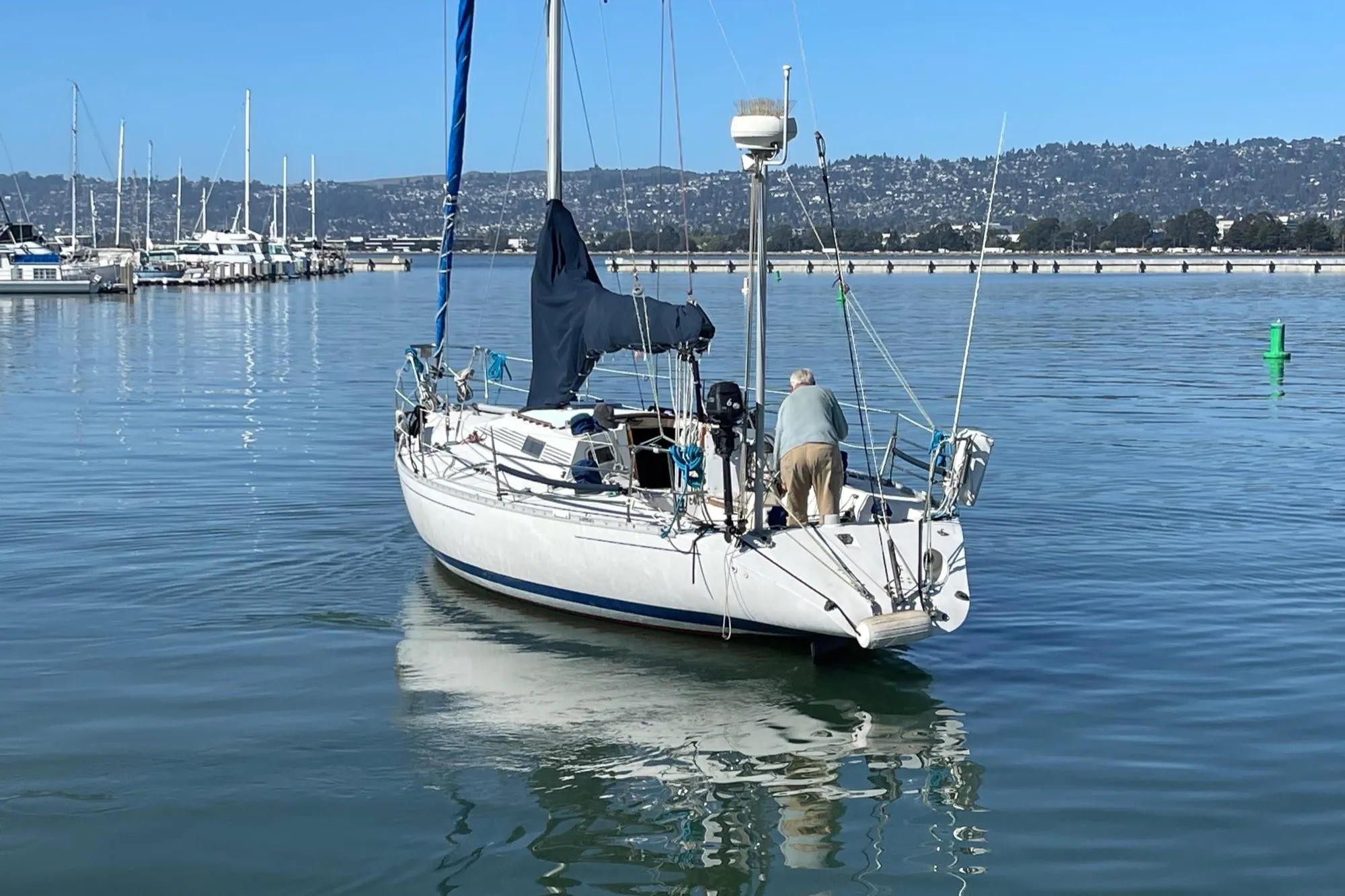 1988 Beneteau First Class 12 sailboat on calm water near marina.
