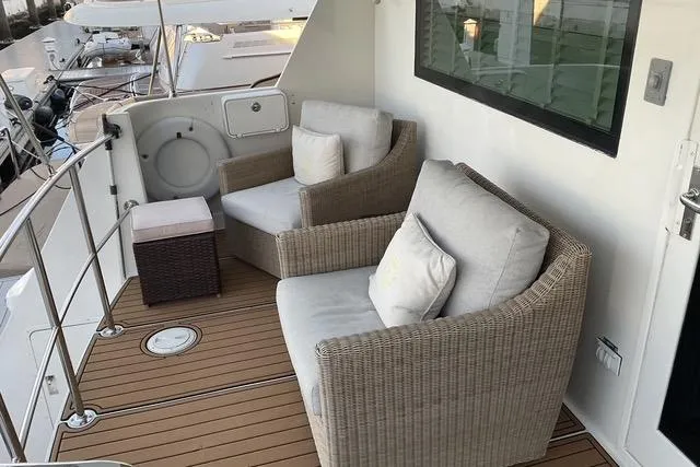 Moor River Yacht Photos Pics Cozy seating area on 1997 Hatteras 70 Sport Deck Motor Yacht with wicker chairs and cushions.