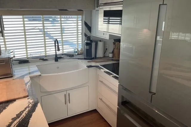 Moor River Yacht Photos Pics Modern kitchen interior on 1997 Hatteras 70 Sport Deck Motor Yacht, featuring sleek appliances and ample lighting.