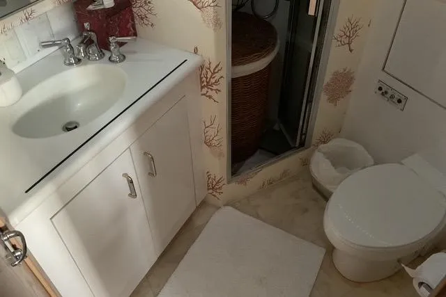 Moor River Yacht Photos Pics Bathroom interior of 1997 Hatteras 70 Sport Deck Motor Yacht with sink and toilet.