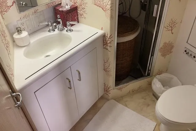 Moor River Yacht Photos Pics Bathroom interior of 1997 Hatteras 70 Sport Deck Motor Yacht with coral-themed wallpaper.