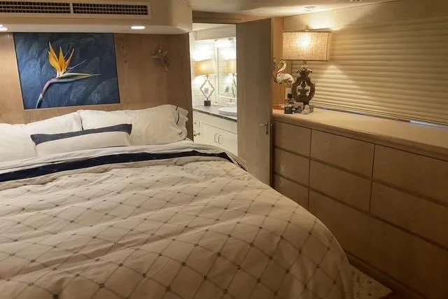Moor River Yacht Photos Pics Luxurious bedroom in a 1997 Hatteras 70 Sport Deck Motor Yacht, featuring elegant decor.