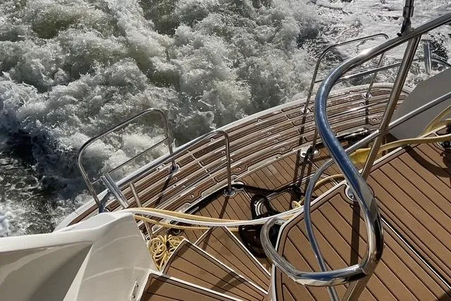 Moor River Yacht Photos Pics Stern view of 1997 Hatteras 70 Sport Deck Motor Yacht with teak steps and ocean waves.