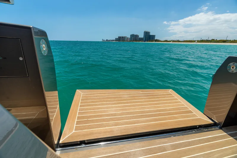 Yours Yacht Photos Pics CNM Continental Tender 2016 yacht platform overlooking ocean and distant city skyline.