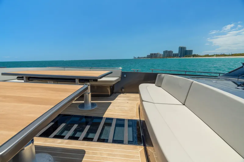 Yours Yacht Photos Pics Luxurious 2016 CNM Continental Tender yacht deck with seating, ocean view, and distant cityscape.