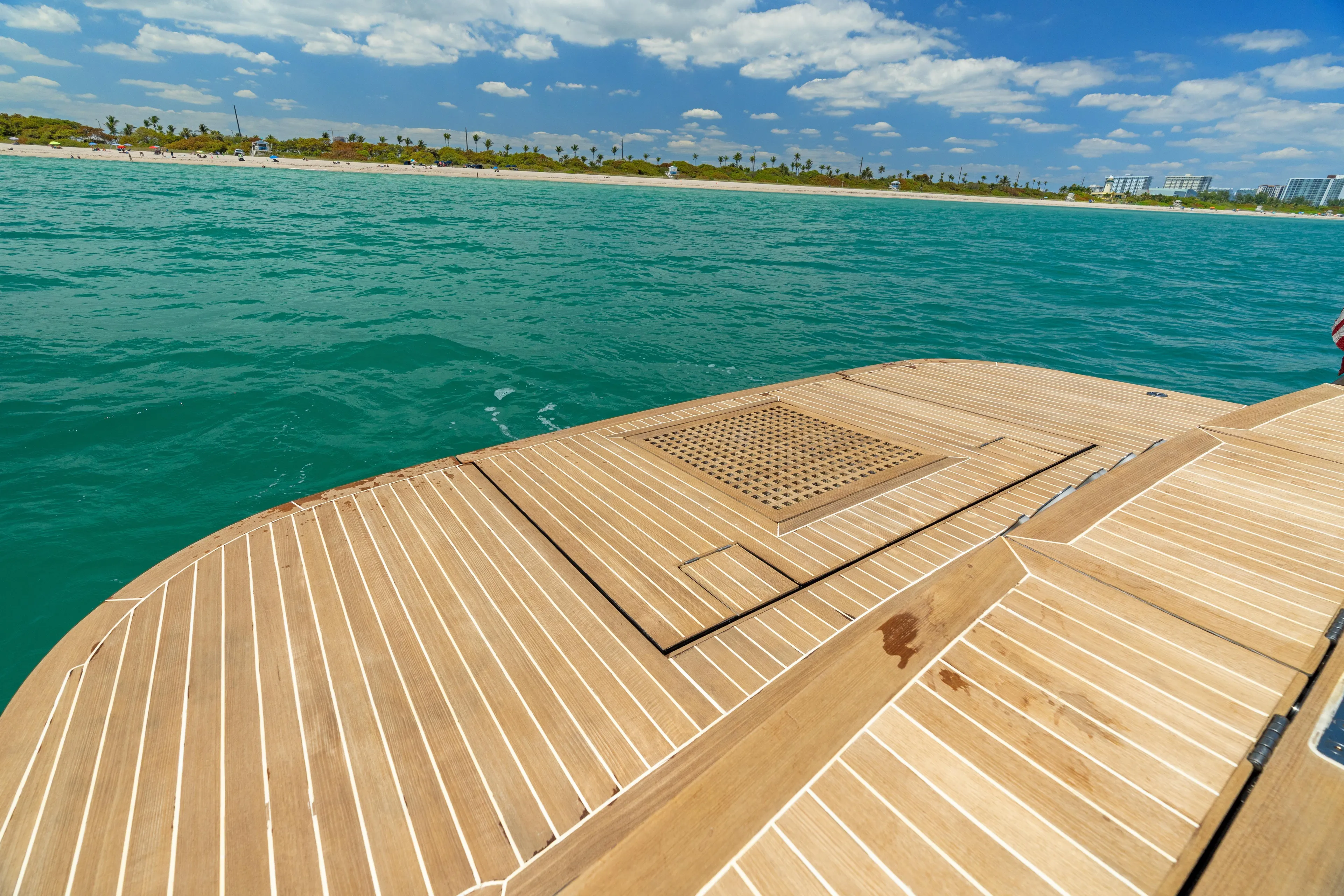 Yours Yacht Photos Pics Teak deck of 2016 CNM Continental Tender on turquoise water, clear sky background.