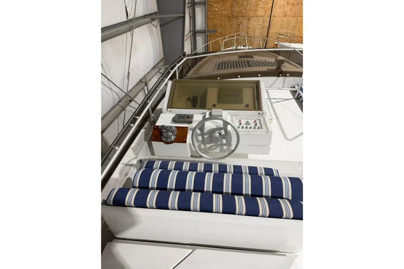  Yacht Photos Pics 1994 Ferretti Yachts 185 Flybridge helm with striped seating in a storage facility.