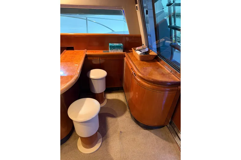  Yacht Photos Pics Luxurious interior of 1994 Ferretti Yachts 185 Fly with wooden cabinetry and stools.