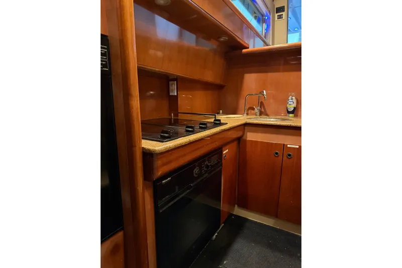  Yacht Photos Pics Galley kitchen in 1994 Ferretti Yachts 185 Fly with wood cabinetry and modern appliances.