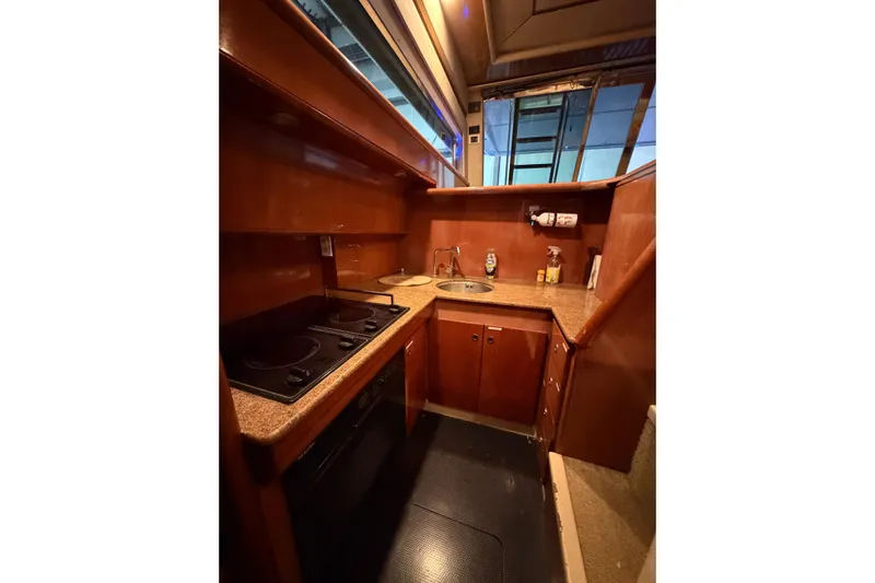  Yacht Photos Pics 1994 Ferretti Yachts 185 Fly kitchen with wooden cabinetry and modern appliances.