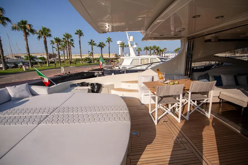 Sofierì Yacht Photos Pics Luxurious 2005 Azimut 68S yacht deck with seating, dining area, and palm tree view.