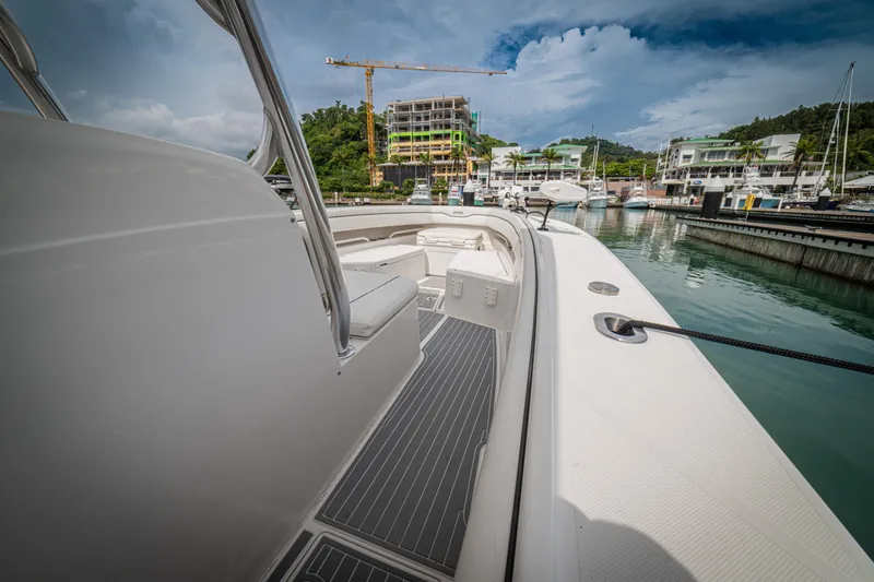 Half Nelson Yacht Photos Pics Luxury Jupiter HFS boat docked in marina, construction and lush greenery in background.