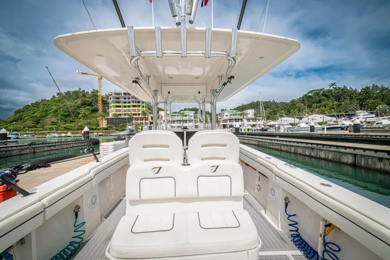 Half Nelson Yacht Photos Pics 2016 Jupiter HFS boat docked at marina, surrounded by lush greenery and construction cranes.